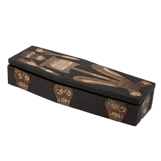 A coffin-shaped decorative box with a black finish and raised gold-toned Egyptian-style artwork, including a pharaoh and skull details, shown on a plain white background.