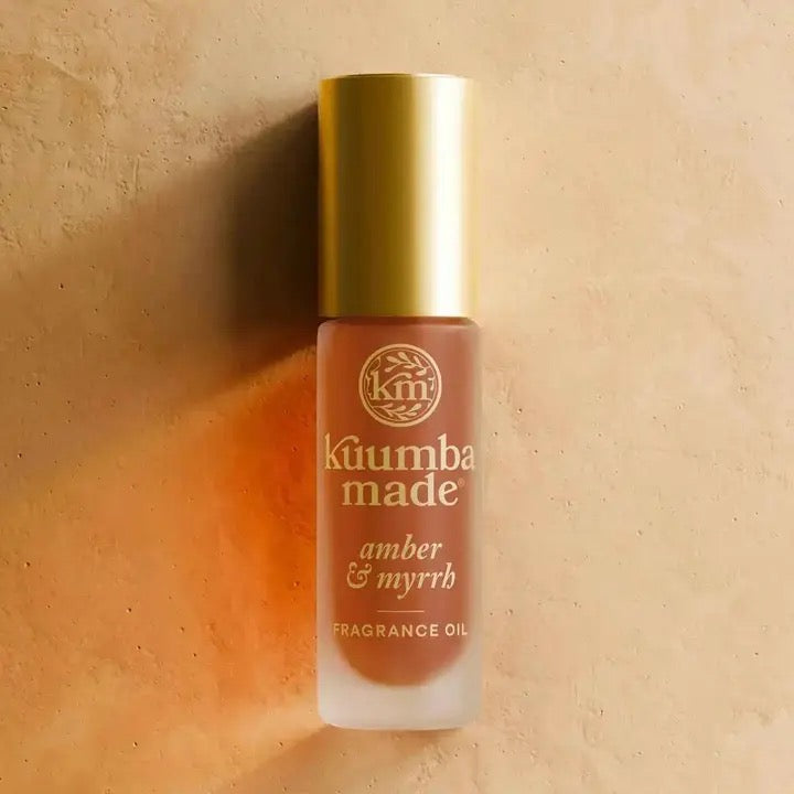 Kuumba Made amber & myrrh fragrance oil bottle on a beige background