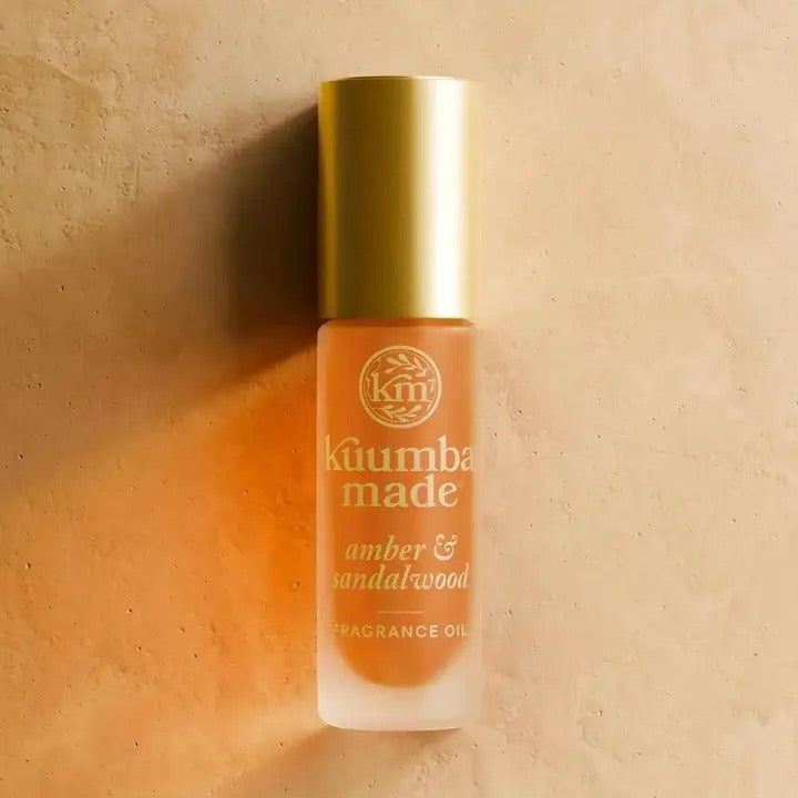 Kåumba Made amber & sandalwood fragrance oil bottle on a beige background