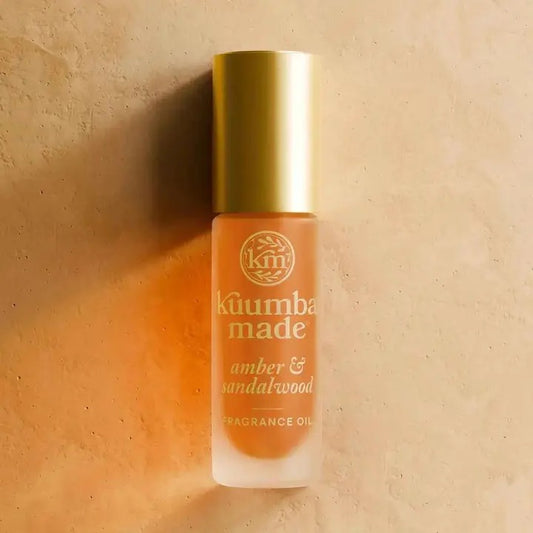 Kåumba Made amber & sandalwood fragrance oil bottle on a beige background