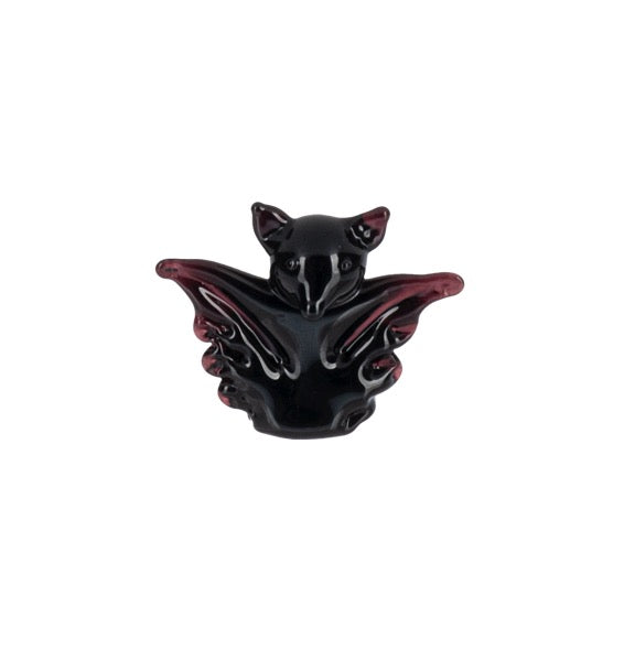A glossy black bat figurine with translucent dark red wings, centered on a plain white background.
