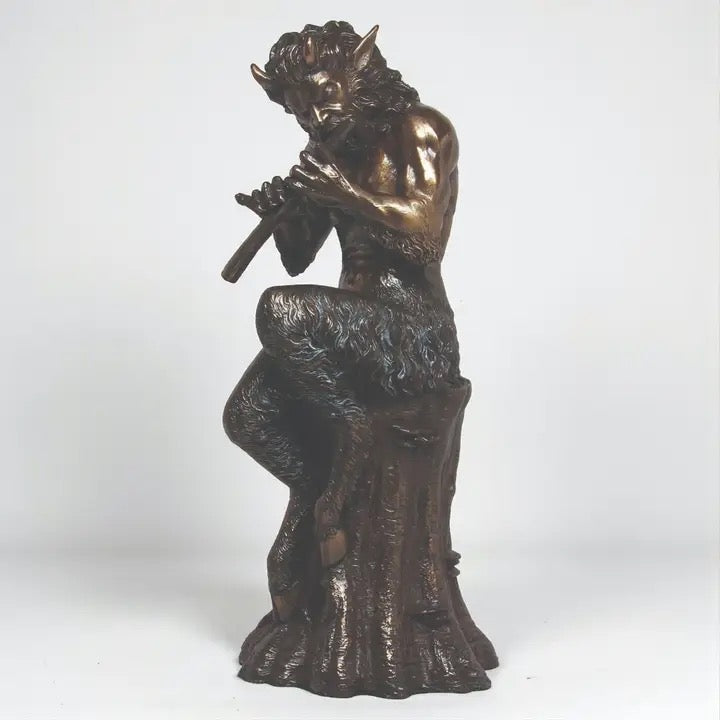 Bronze statue of a satyr playing a flute on a white background