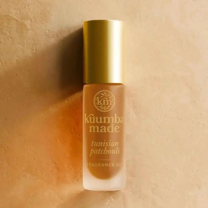 Perfume bottle labeled 'kuumba made' on a beige background