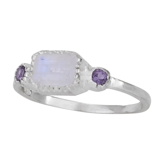 Silver ring with a moonstone and two purple gemstones on a white background
