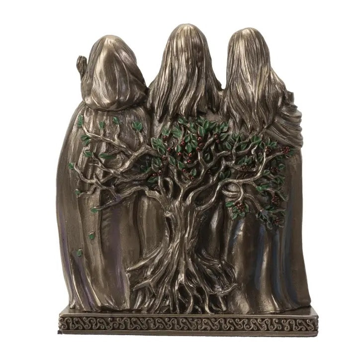 Bronze statue of three hooded figures with a tree