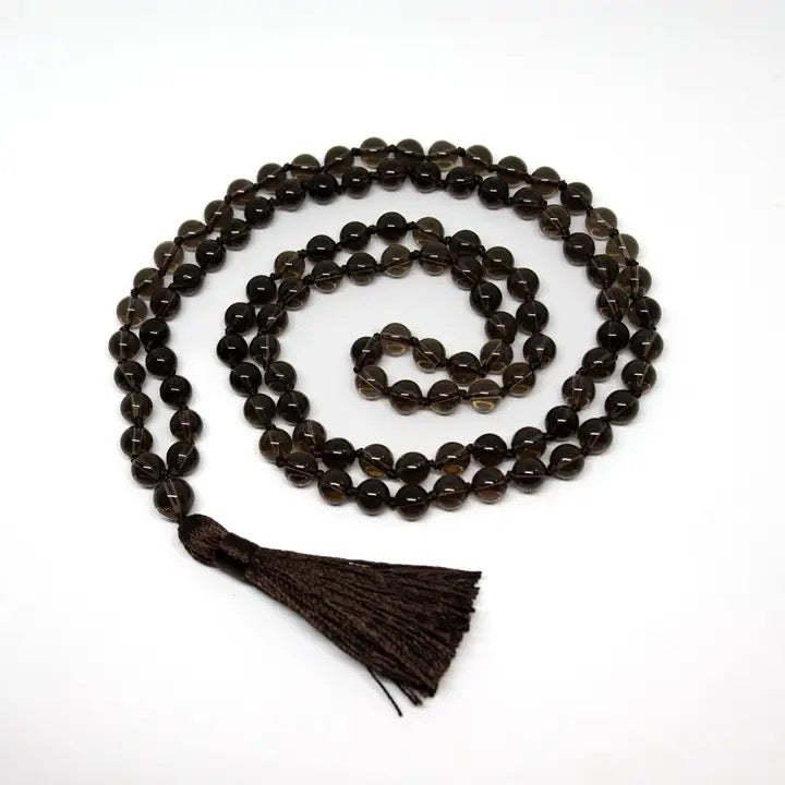 Black beaded necklace with a tassel on a white background
