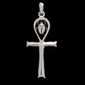 Silver cross pendant with a scarab design on a black background