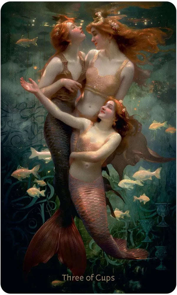 A fantasy art print or card titled 'Three of Cups' showing three mermaids underwater, with red hair, gold and bronze tails, and small fish swimming around them.