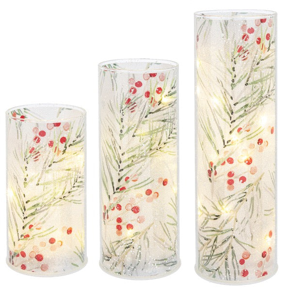 Set of three cylindrical LED candles with floral design on a white background