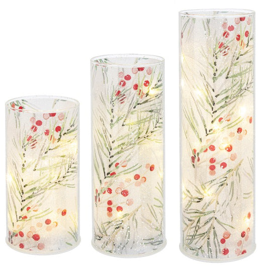 Set of three cylindrical LED candles with floral design on a white background