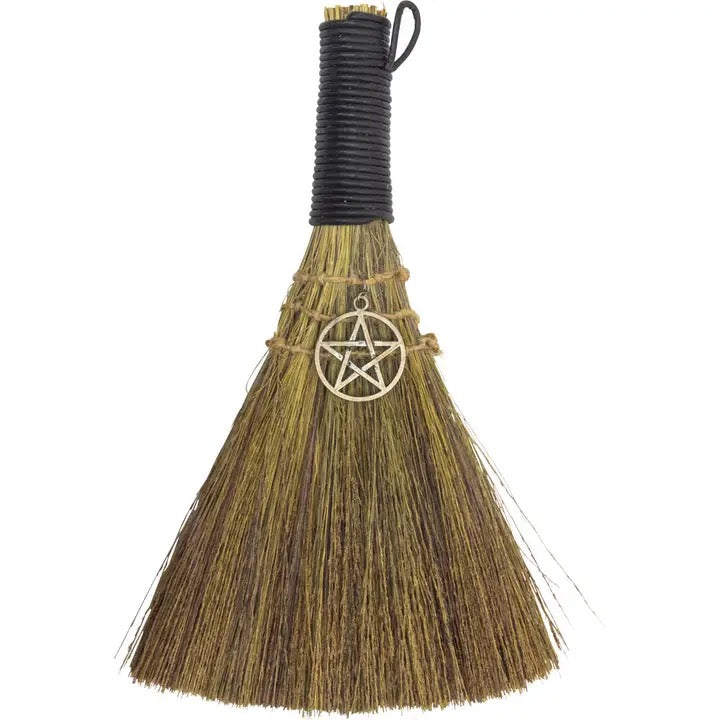 Broom with pentacle charm on a white background