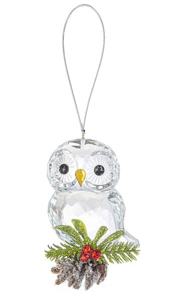 Glass owl ornament with greenery and berries on a white background