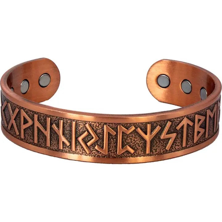 Copper bracelet with engraved symbols on a white background