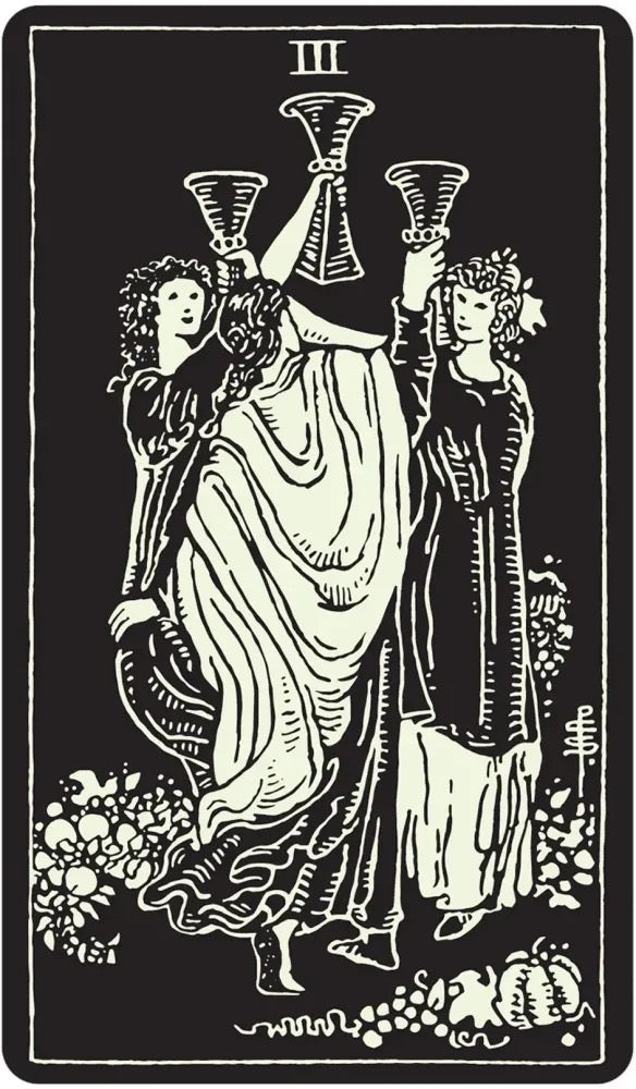 A black and white tarot card illustration showing three classical figures carrying cups, with the Roman numeral III at the top and floral and pumpkin motifs at the bottom.
