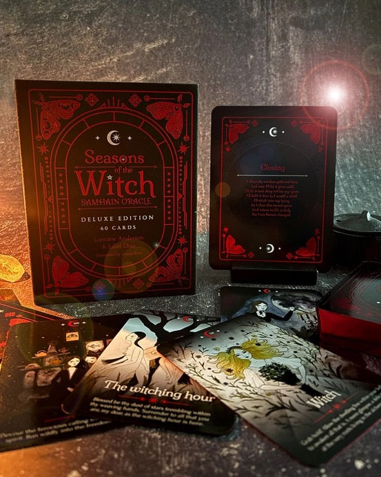 Seasons of the Witch Samhain Oracle Deck Deluxe Edition card set displayed on a dark textured surface, showing the red and black box, a card back, and several illustrated oracle cards.