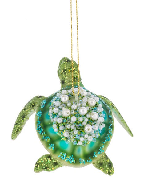 Decorative turtle ornament with pearls on a white background