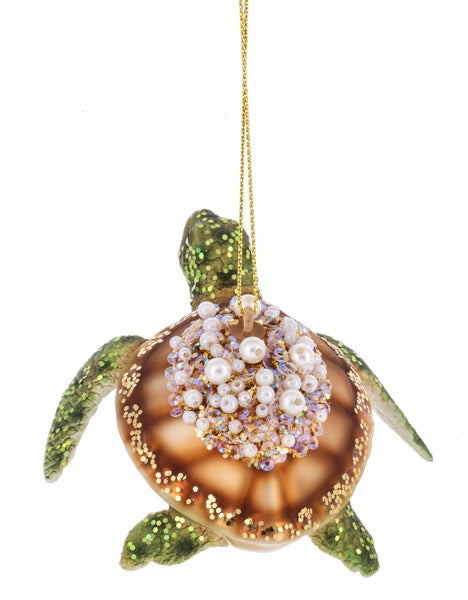 Decorative turtle ornament with pearl embellishments on a white background