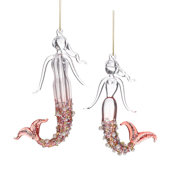 Two mermaid-shaped ornaments with pink tails on a white background