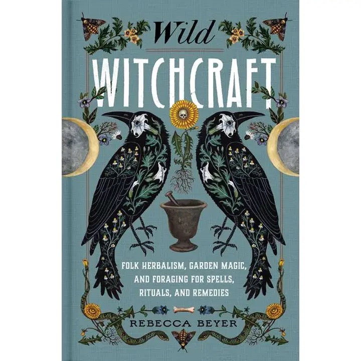 Book cover of 'Wild Witchcraft' by Rebecca Beyer, featuring two detailed black raven illustrations with floral patterns, a mortar and pestle, and celestial elements on a muted blue-green background.