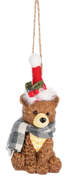Decorative bear ornament with scarf, hat, and candle on a white background