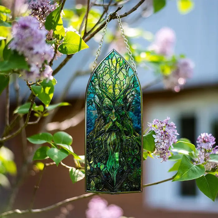 Decorative stained glass panel with a green figure hanging among flowers