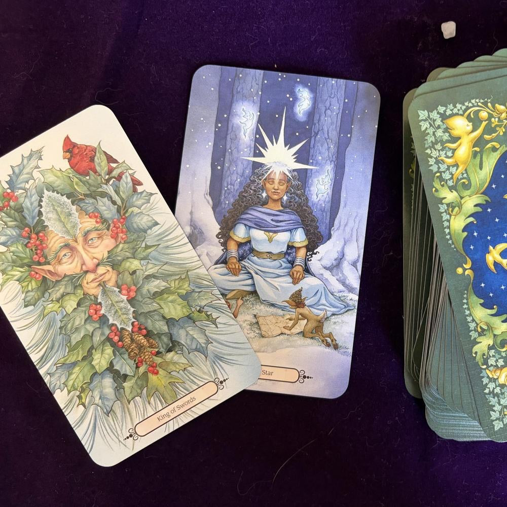 Three tarot cards on a dark purple surface