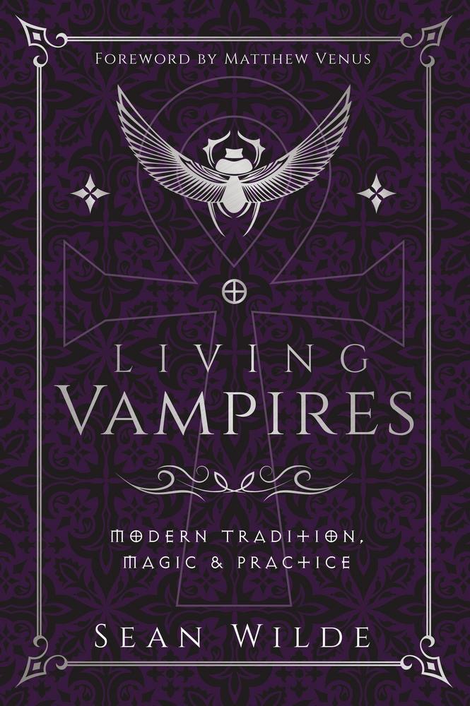 Book cover for 'Living Vampires: Modern Tradition, Magic & Practice' by Sean Wilde, featuring a dark purple ornate background with a silver winged emblem and decorative border.