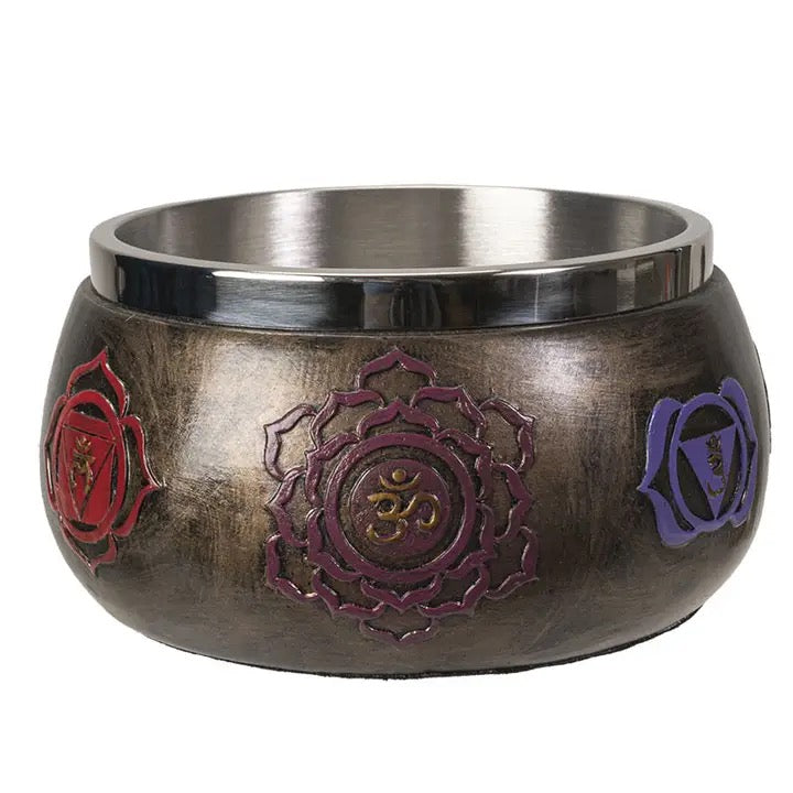 Decorative metal bowl with chakra symbols on a white background