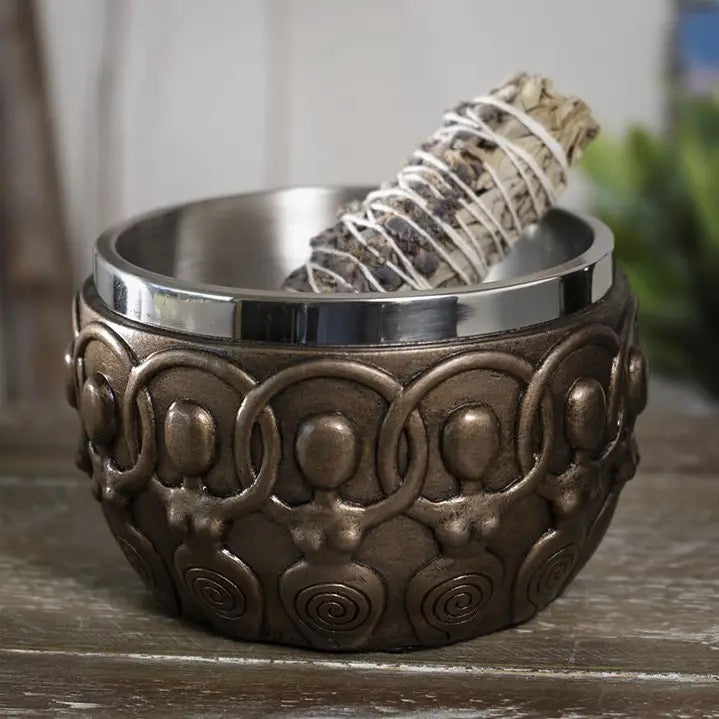 Decorative bronze looking bowl with a silver interior on a wooden surface