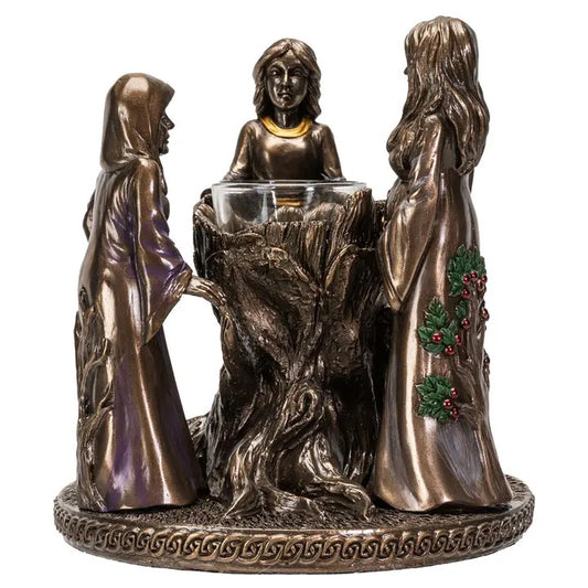 Bronze-like figurine of three women around a central bowl with decorative elements on a white background