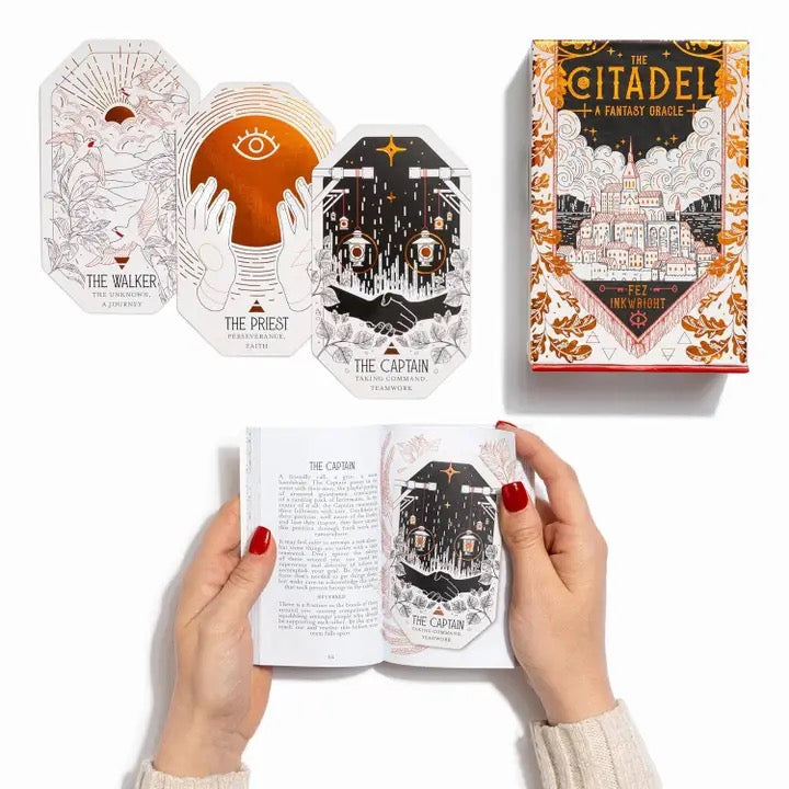 Fantasy oracle cards with detailed illustrations and a person holding an open card.
