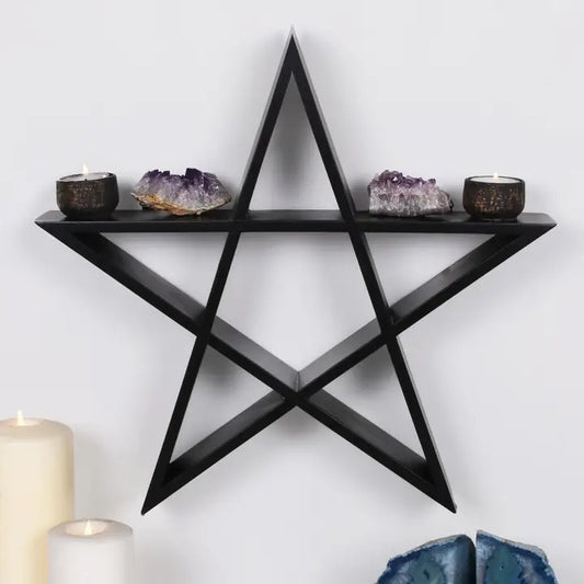 Black star-shaped wall shelf with decorative items on a white wall.