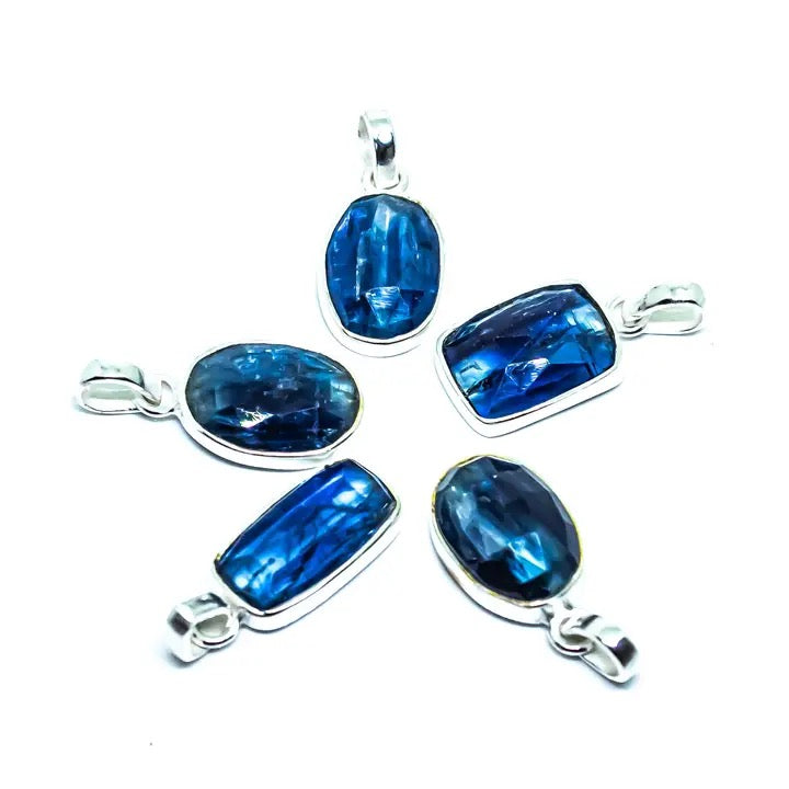 Set of blue gemstone pendants with silver settings on a white background