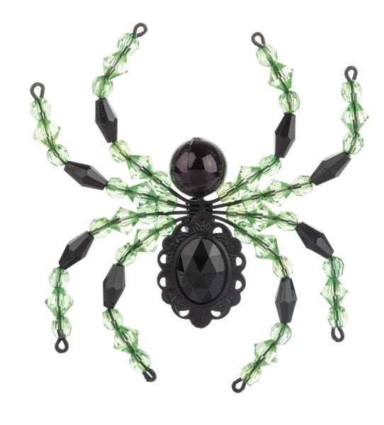 Decorative spider with green web and black beads on a white background