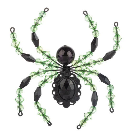 Decorative spider with green web and black beads on a white background