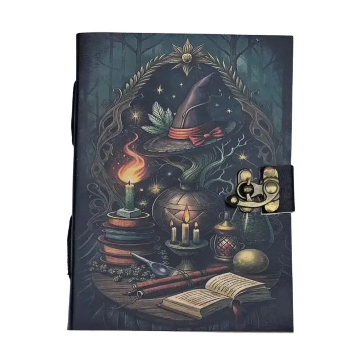 A leather journal with a dark, mystical illustration featuring a witch's hat, candles, an open book, and magical objects under a starry night sky, secured with a brass clasp on the right side.