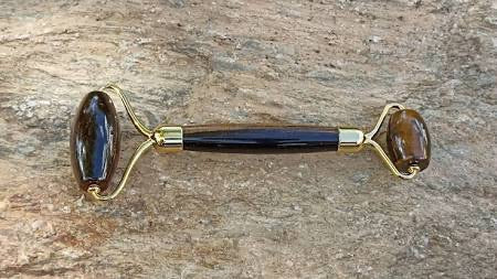 Tiger Eye massage roller on stone background