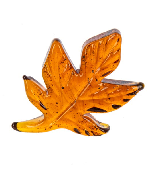 Decorative leaf-shaped object with a speckled pattern on a white background