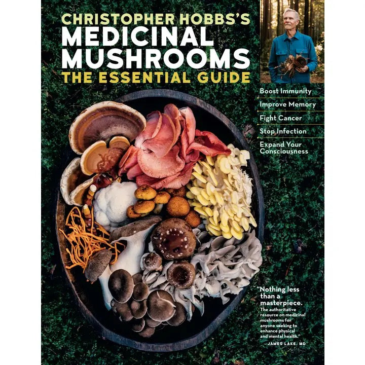Book cover of 'Christopher Hobbs's Medicinal Mushrooms: The Essential Guide' featuring a large overhead photo of assorted mushrooms in a bowl, with the title in bold white and yellow text on a dark forest background and a small inset photo of Christopher Hobbs in a forest.