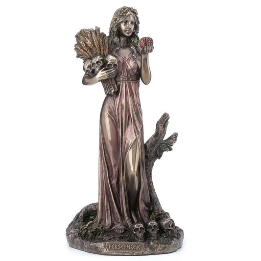 Statue of a woman in a flowing dress holding an apple and skull, with a white background.