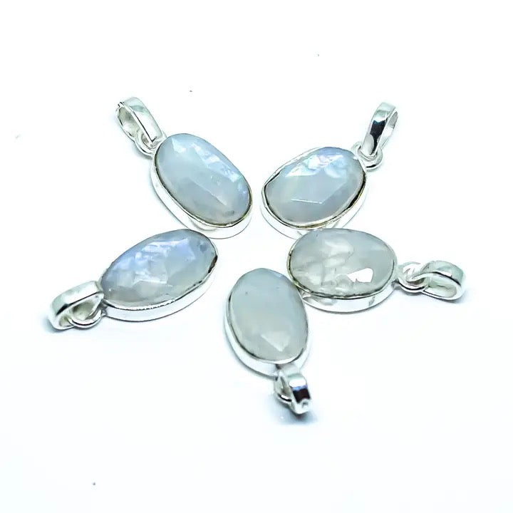 Four silver pendants with moonstone stones on a white background