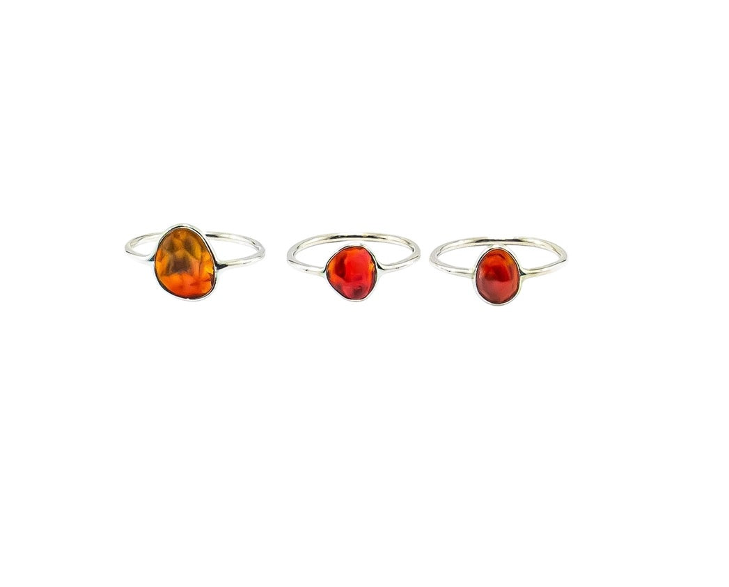 Three Fire Opal ring pendants on a white background