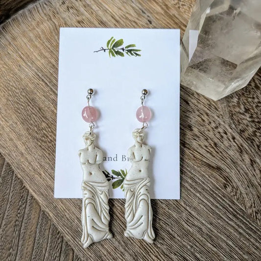 Pair of earrings on a card with a wooden background