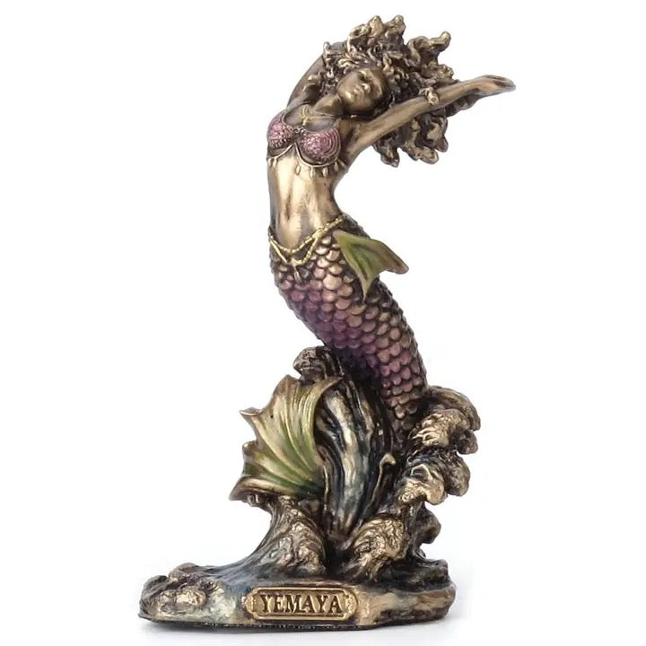 Mermaid figurine with purple tail and gold accents on a white background