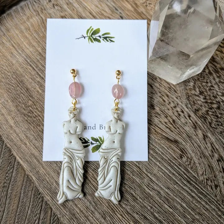 Pair of earrings on a card with a wooden background