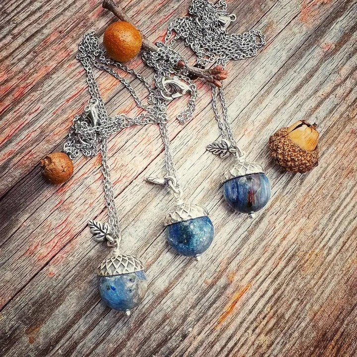 Necklace with blue stone pendants and acorn charms on a wooden surface