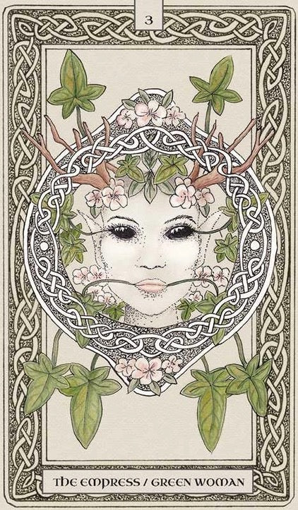 A tarot card illustration titled 'The Empress / Green Woman' showing a stylized face framed by Celtic knotwork, green leaves, and pale pink flowers on an off-white background.