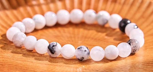 Bracelet with white and black beads on a wooden surface