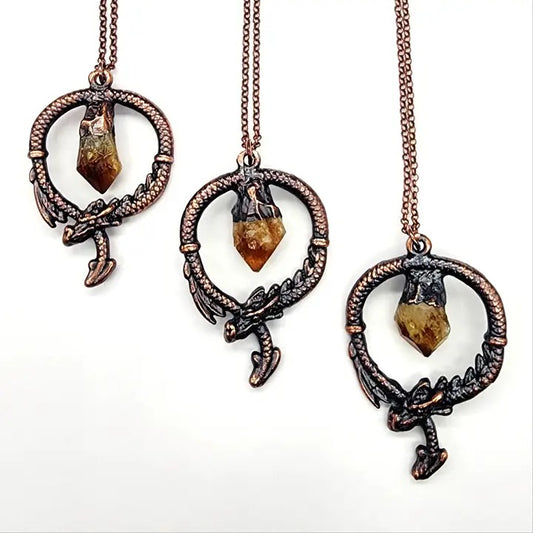 Three ornate necklaces with gemstone pendants on a white background
