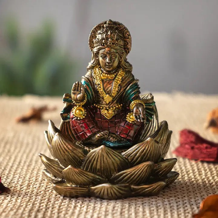 Decorative statue of a seated figure on a lotus flower with intricate details.